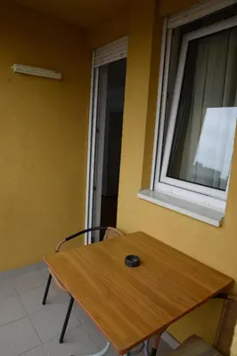 a wooden table in a room with a window at Zap apartman in Belgrade
