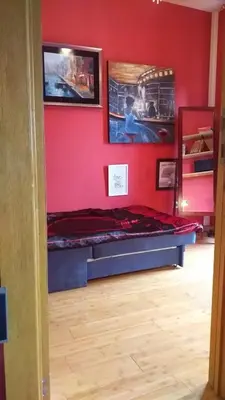 a room with a red wall with a bed and pictures at LOVE in Belgrade