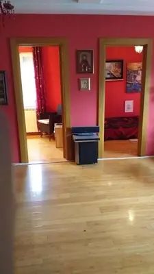a living room with red walls and a wooden floor at LOVE in Belgrade