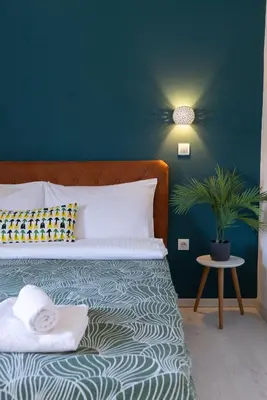 a bedroom with a bed with a green wall at Rooster apartments in Belgrade