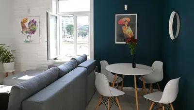 a blue room with a couch and a table and chairs at Rooster apartments in Belgrade