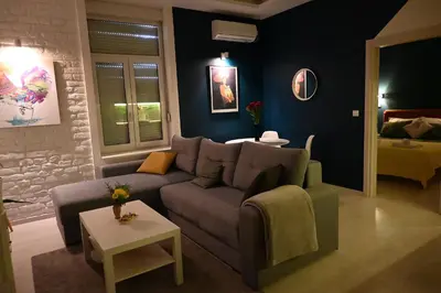 a living room with a couch and a table at Rooster apartments in Belgrade