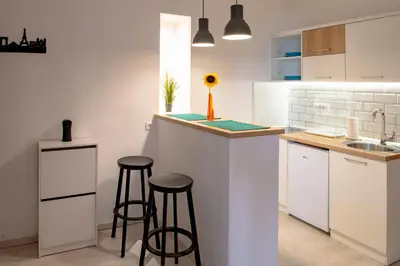 a kitchen with two stools at a counter with a sink at Rooster apartments in Belgrade