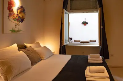 a bedroom with a bed with a window with a chicken on it at Rooster apartments in Belgrade