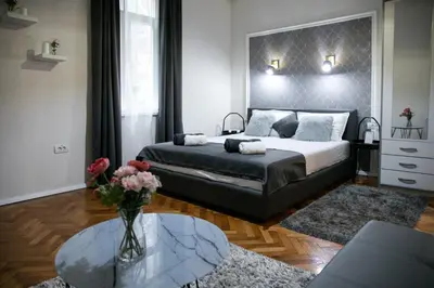a bedroom with a bed and a vase of flowers on a table at Natalie's Place in Belgrade