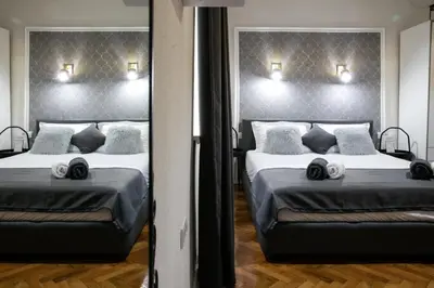 two beds in a room with two mirrors at Natalie's Place in Belgrade