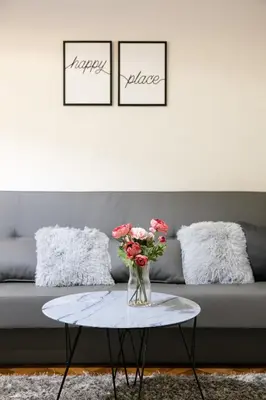 a living room with a couch and a table with flowers at Natalie's Place in Belgrade