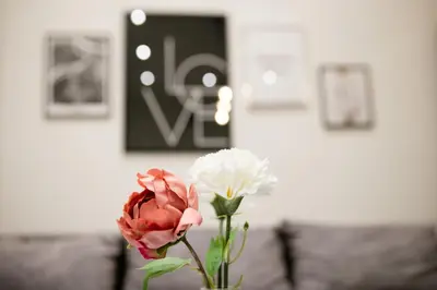 a vase filled with pink and white flowers on a table at Natalie's Place in Belgrade