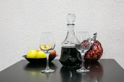 two wine glasses and a bottle and a bowl of fruit at Natalie's Place in Belgrade