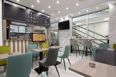 a restaurant with tables and chairs and a tv at Omia in Belgrade