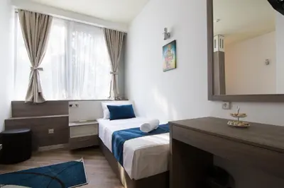 a small bedroom with a bed and a mirror at Omia in Belgrade