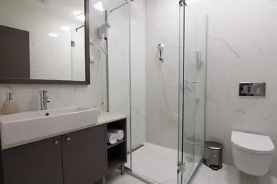 a bathroom with a shower and a sink and a toilet at Omia in Belgrade