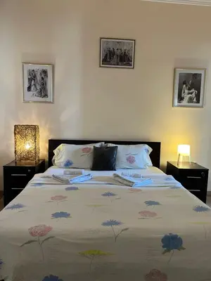 a bedroom with a large bed with a floral bedspread at Terazije Square Lux Apartment in Belgrade