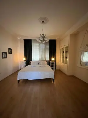 a large bedroom with a white bed and a chandelier at Terazije Square Lux Apartment in Belgrade