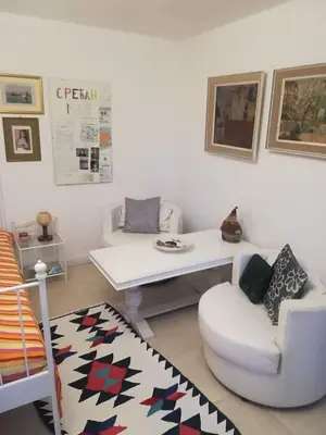 a living room with a couch and a table and a chair at Šumska kuća Sandy in Banatski Karlovac