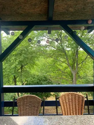 two chairs sitting on a porch looking out of a window at Šumska kuća Sandy in Banatski Karlovac