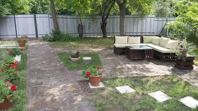 a patio with a couch and some plants in a yard at Šumska kuća Sandy in Banatski Karlovac
