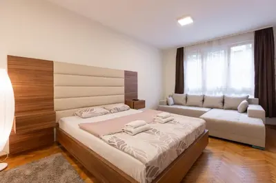 a bedroom with a bed and a couch at Central Park Apartments in Belgrade