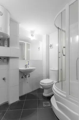 a white bathroom with a toilet and a sink at Central Park Apartments in Belgrade