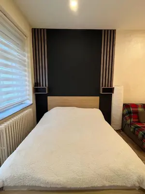 a bedroom with a white bed with a window at Apartment Bubble in Belgrade