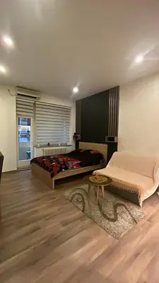 a bedroom with two beds and a table at Apartment Bubble in Belgrade