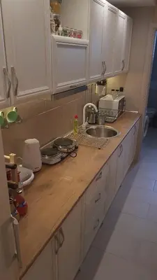 a kitchen with white cabinets and a wooden counter top at Apartments Exclusive in Belgrade