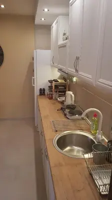 a kitchen with a stainless steel sink and white cabinets at Apartments Exclusive in Belgrade