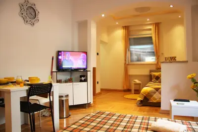 a living room with a television and a table and a couch at St. Marko Church App in Belgrade