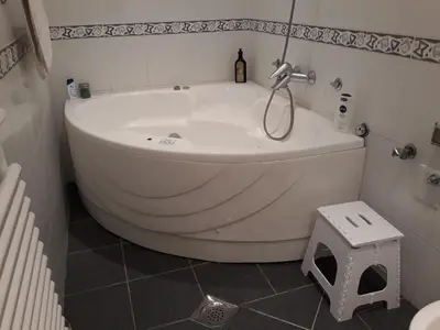 a white bath tub in a bathroom with a toilet at St. Marko Church App in Belgrade