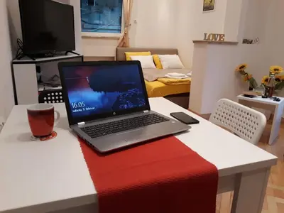 a laptop computer sitting on a table in a living room at St. Marko Church App in Belgrade