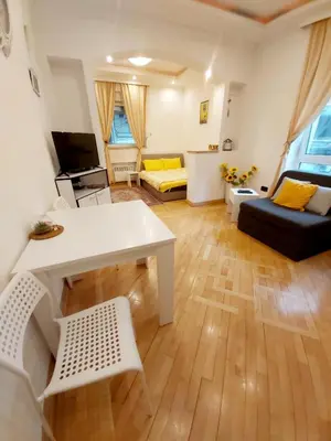 a living room with a white table and a couch at St. Marko Church App in Belgrade