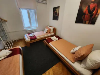 a room with two beds and a window at BUDGET - Authentic Belgrade Centre Apartment #4, 3 Bedrooms, 1 full Bathroom, 1 Toilet in Belgrade