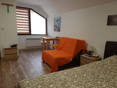 a room with a bed and a chair and a table at Ćukovac studios in Belgrade