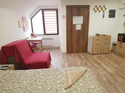 a room with a bed and a chair and a table at Ćukovac studios in Belgrade