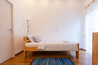 a bedroom with a bed and a rug on a wooden floor at Your ONE and ONLY in Belgrade