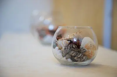 a glass bowl filled with rocks and seashells on a table at Your ONE and ONLY in Belgrade