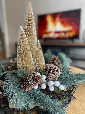 a table topped with a christmas centerpiece with pine cones at Apartment Unamare in Belgrade