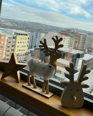 two wooden reindeeritures sitting on a window sill at Apartment Unamare in Belgrade