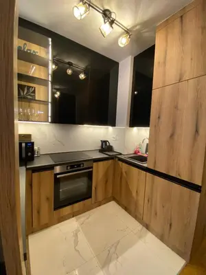 a kitchen with wooden cabinets and a stove top oven at Apartment Unamare in Belgrade