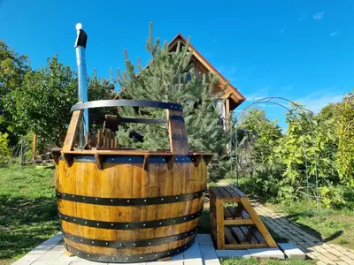 a wooden wine barrel sitting next to a wooden stool at Vila Stancevic wellness in Sremski Karlovci