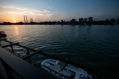 a boat on the water with the sunset in the background at FLOW in Belgrade
