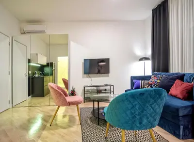 a living room with a blue couch and pink chairs at Momo 123 Apartments in Belgrade