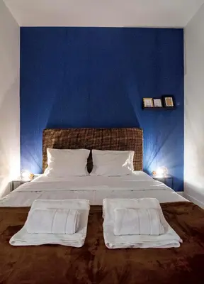 a bedroom with a large bed with a blue wall at Momo 123 Apartments in Belgrade