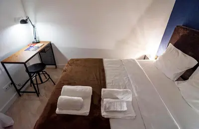 a bedroom with a bed with two pillows and a desk at Momo 123 Apartments in Belgrade
