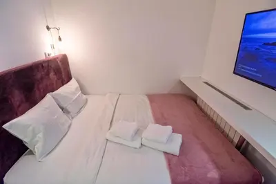 a small bedroom with two white towels on a bed at Momo 123 Apartments in Belgrade