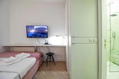 a bedroom with a bed and a desk and a window at Momo 123 Apartments in Belgrade