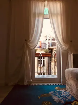 a window with curtains and a view of a balcony at Momo 123 Apartments in Belgrade