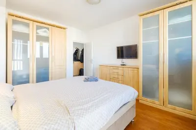 a white bedroom with a bed and a tv at BB´s Apartment&Unterkunft in Belgrade