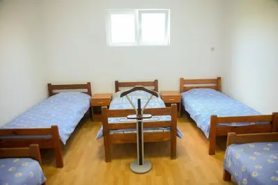 a room with three beds and a table in it at Prenociste Pecinci in Pećinci