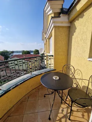 a table and chairs on a balcony with a view at Danube duplex apartment in Smederevo